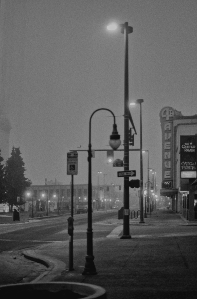 Image of Anchorage's 4th Avenue at night in the fog with the art deco 4th Avenue theater sign prominent.